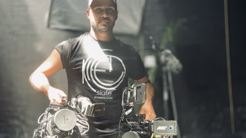 Crew member in a KleenSlate tee operating a camera rig